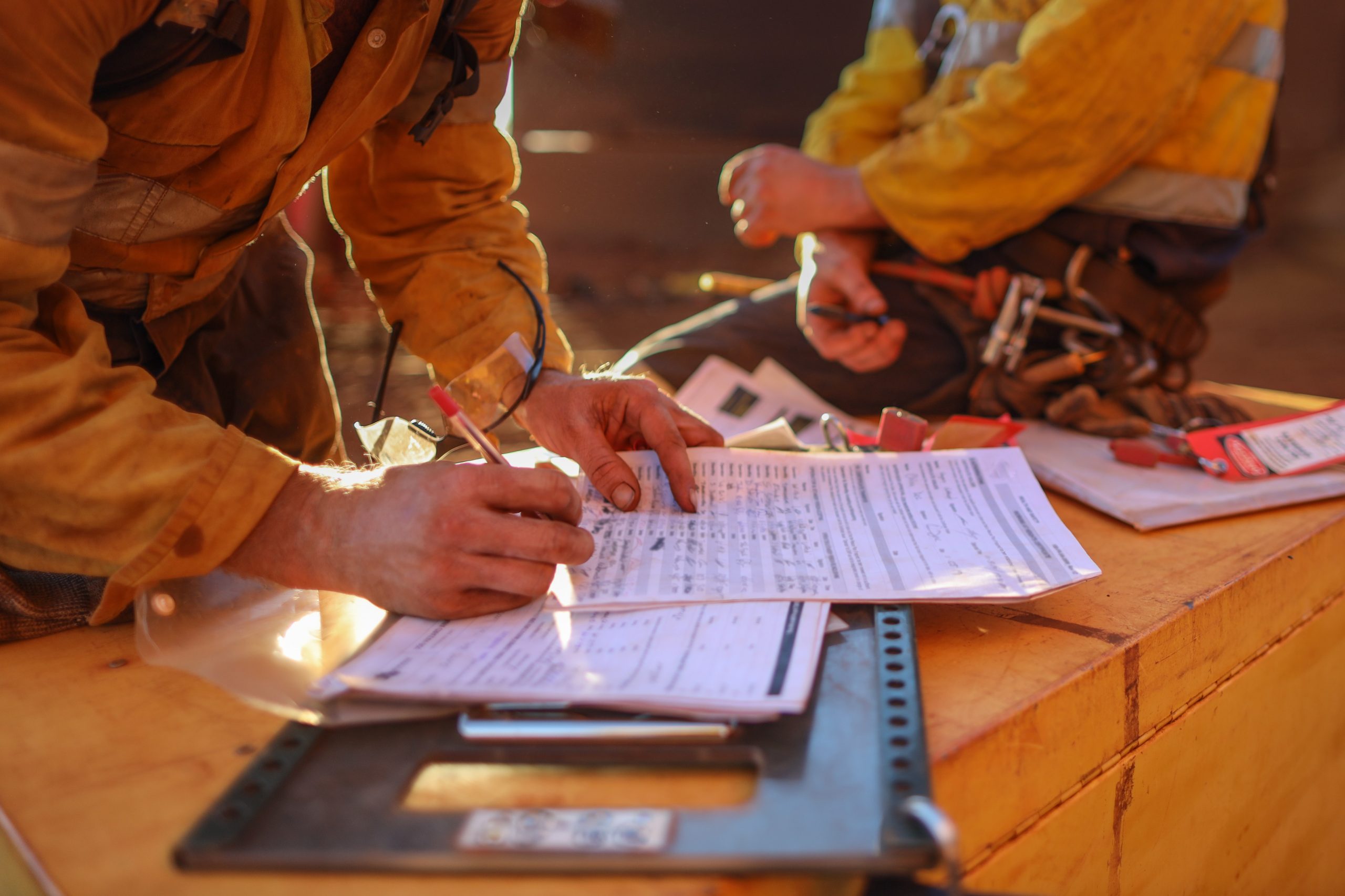 Miners sign of the work permit on isolation safety control lock box after completed rope access hight risk work 12 Hrs shift construction mine site, Perth, Australia