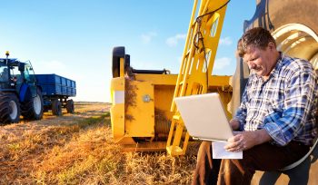 Farmer counts profits on a computer