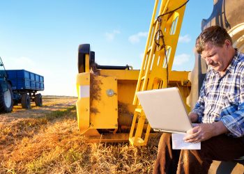 Farmer counts profits on a computer