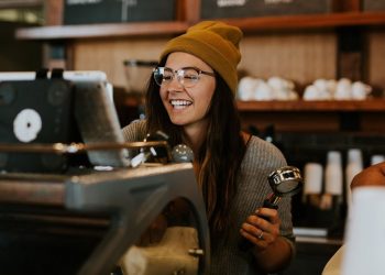 Staff Member smiling while making a coffee at a coffee machine