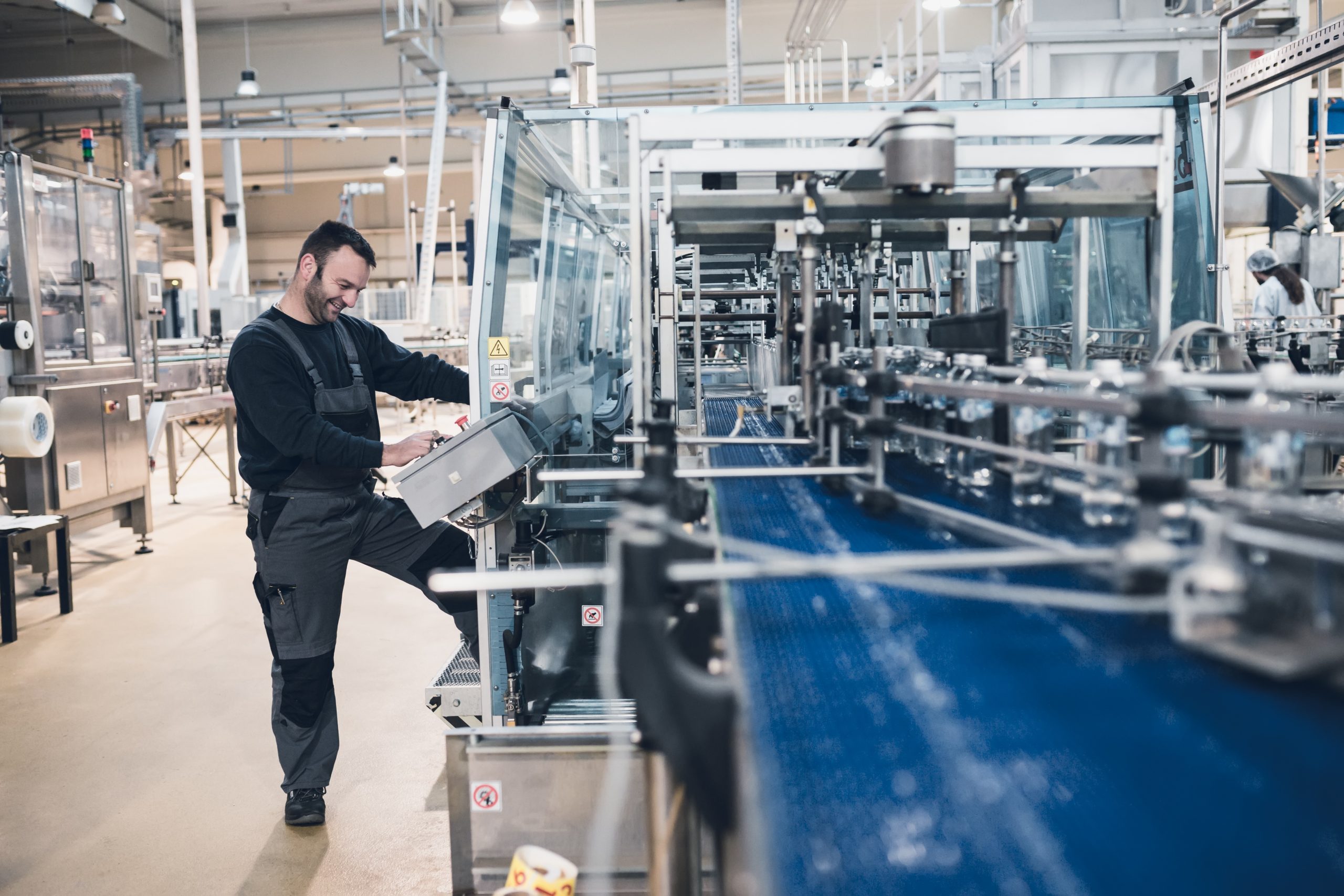 Happy smiled worker doing his job on Robotic factory line for pr