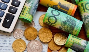 Australian bills and coins scattered on a table with a calculator